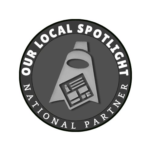 Circular badge with the words "Our Local Spotlight National Partner" and a central icon resembling a cape with a clipboard or card.